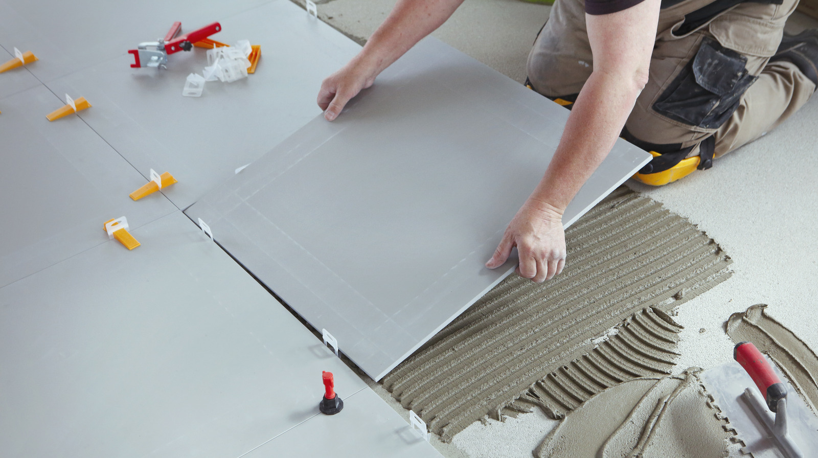 Professional tiler installing new tiles on the floor.